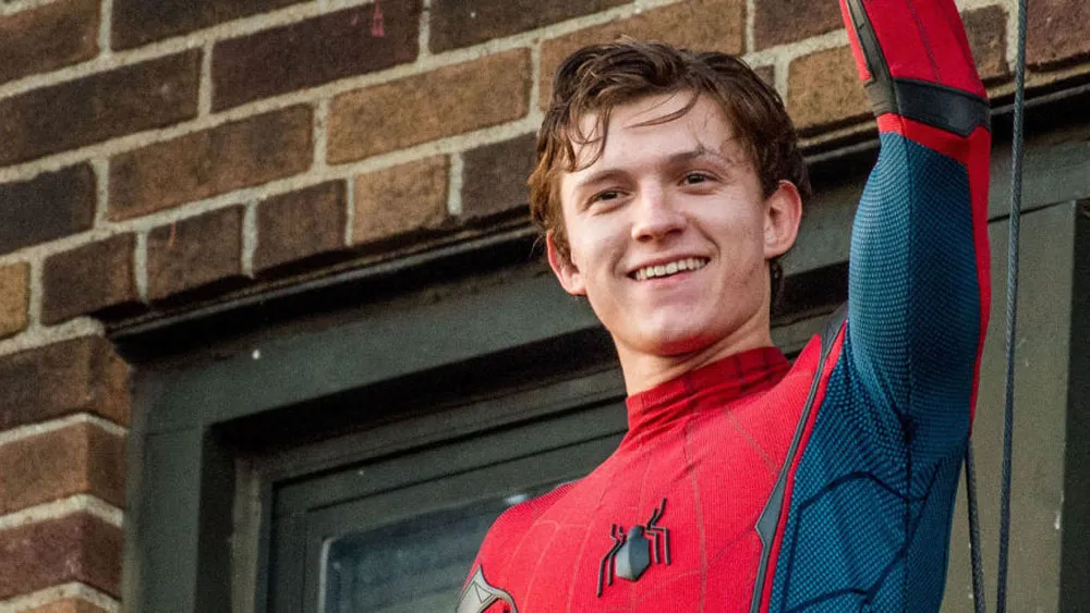 tom holland saludando con traje de spiderman